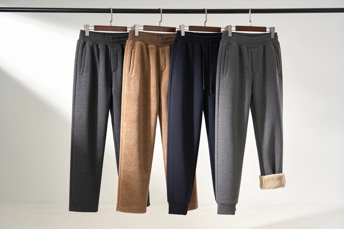 Representative lot of F/W brushed trousers - charcoal, camel fleece, navy and grey fleece-lined joggers on a rail