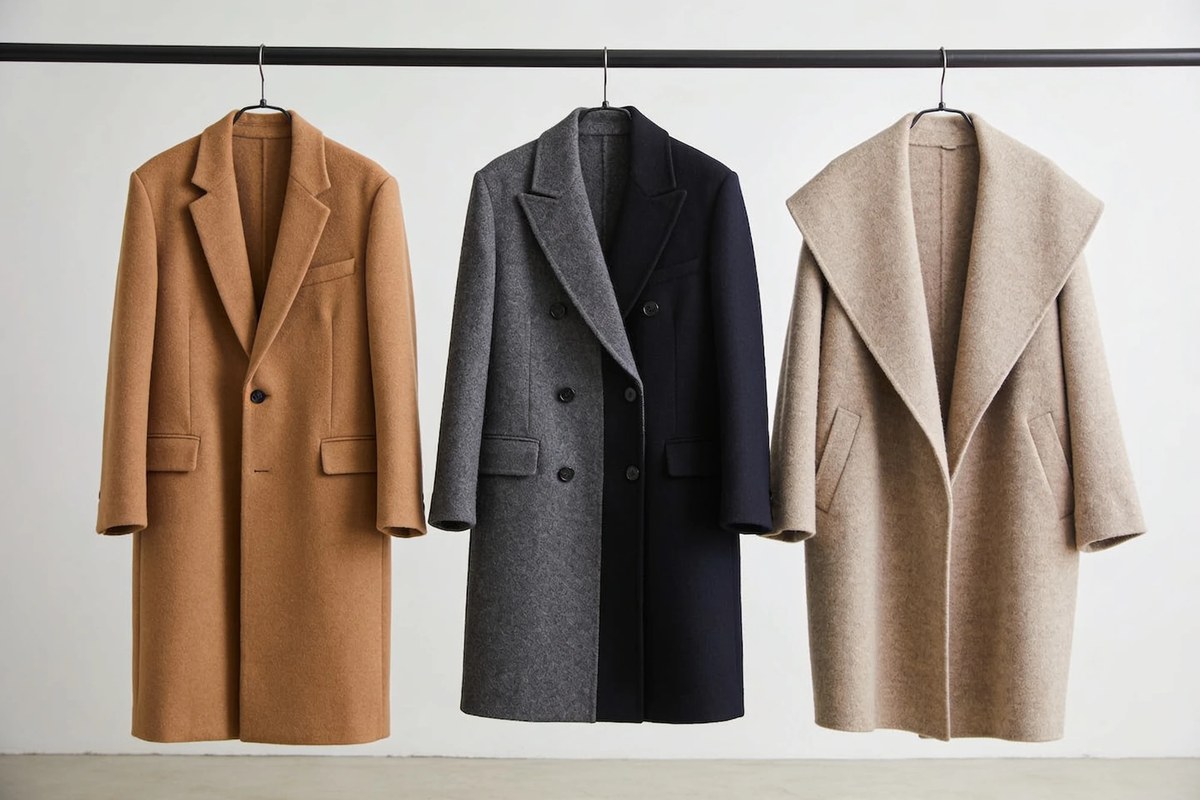 Representative lot of F/W wool coats - camel single-breasted, grey and navy double-breasted, and an oatmeal shawl-collar coat on a rail